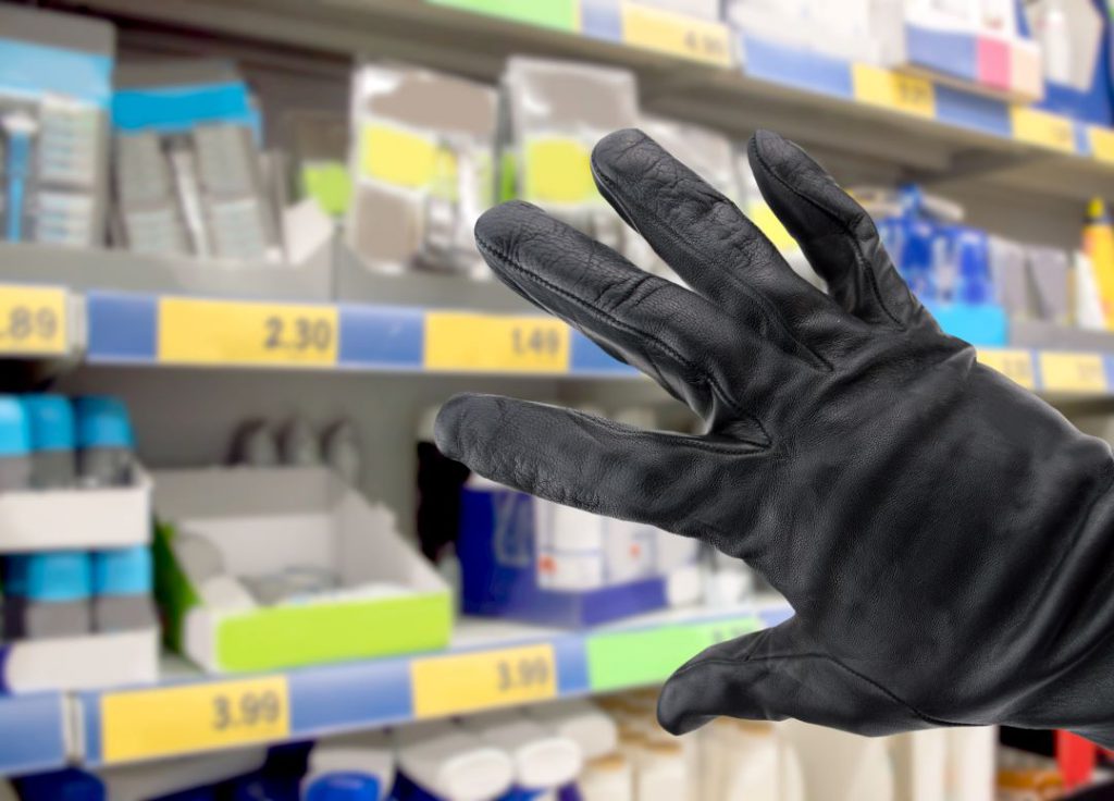 Mano di un ladro che ruba presso un negozio retail