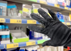 Mano di un ladro che ruba presso un negozio retail